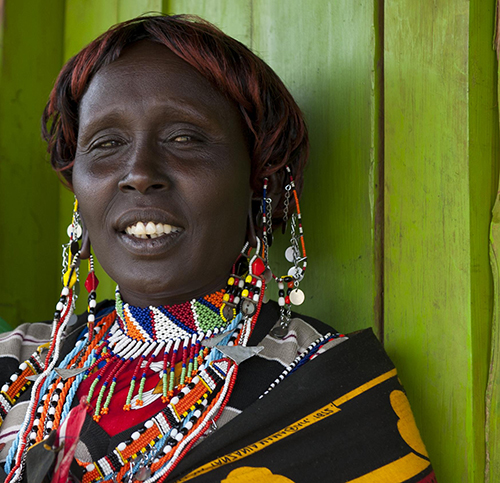 A woman standing against a green wall