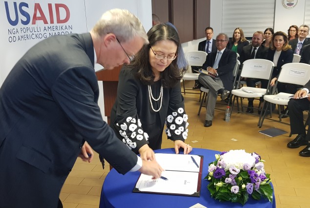 Ambassador Delawie and Lisa Magno sign the Oath of Office 