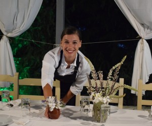 Girl prepares table for dinner at hotel.