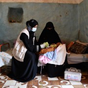 A USAID-trained midwife provides health services to a mother and baby.