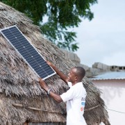 A Baobab Plus agent putting solar panel on a house