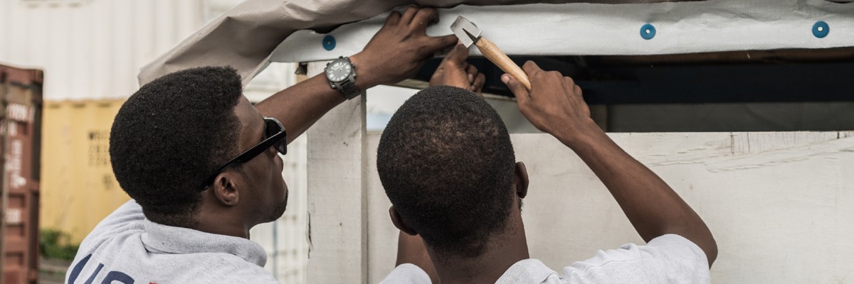 Two men rebuilding roofs after Hurricane Matthew